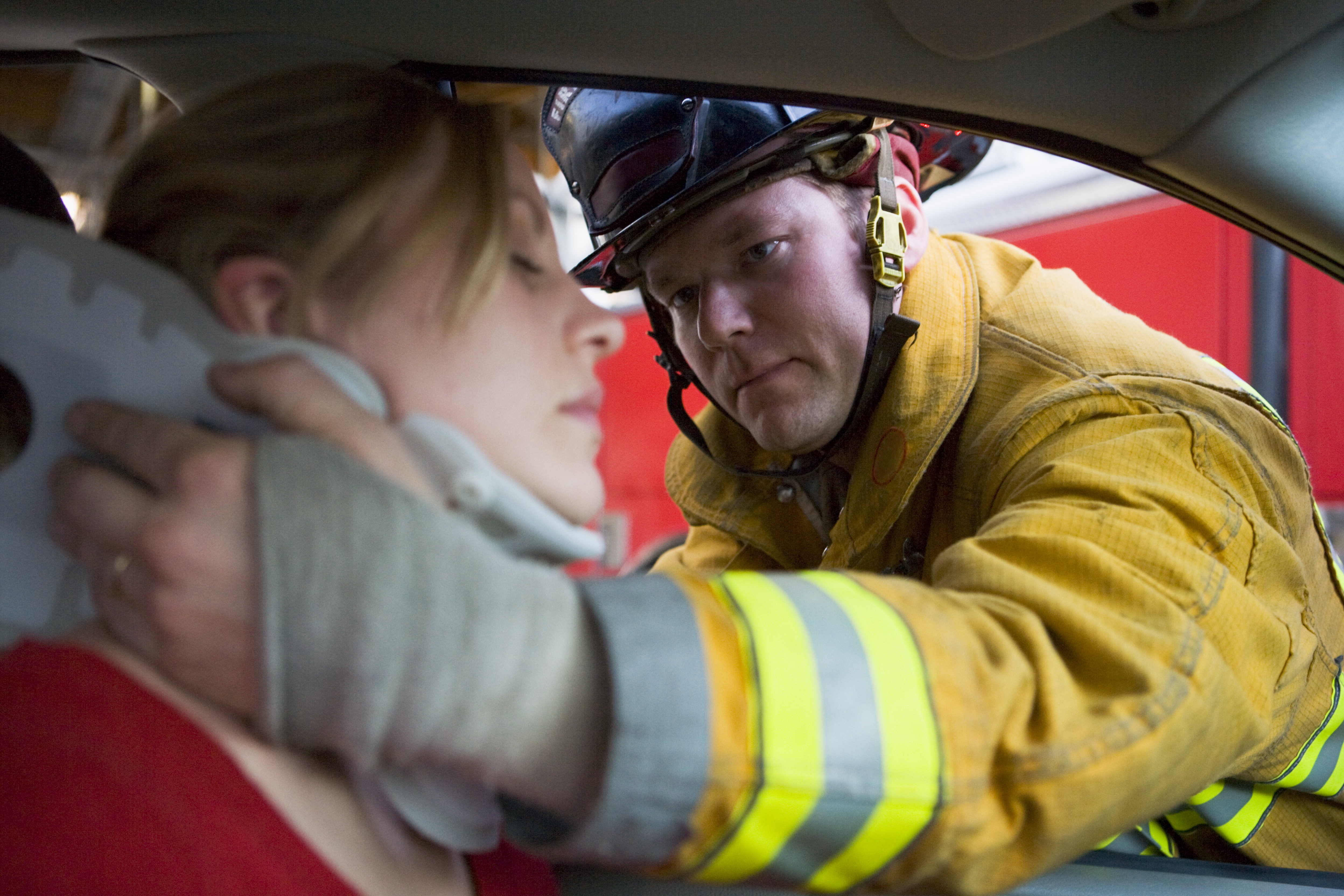 Firefighter putting neck brace on victim