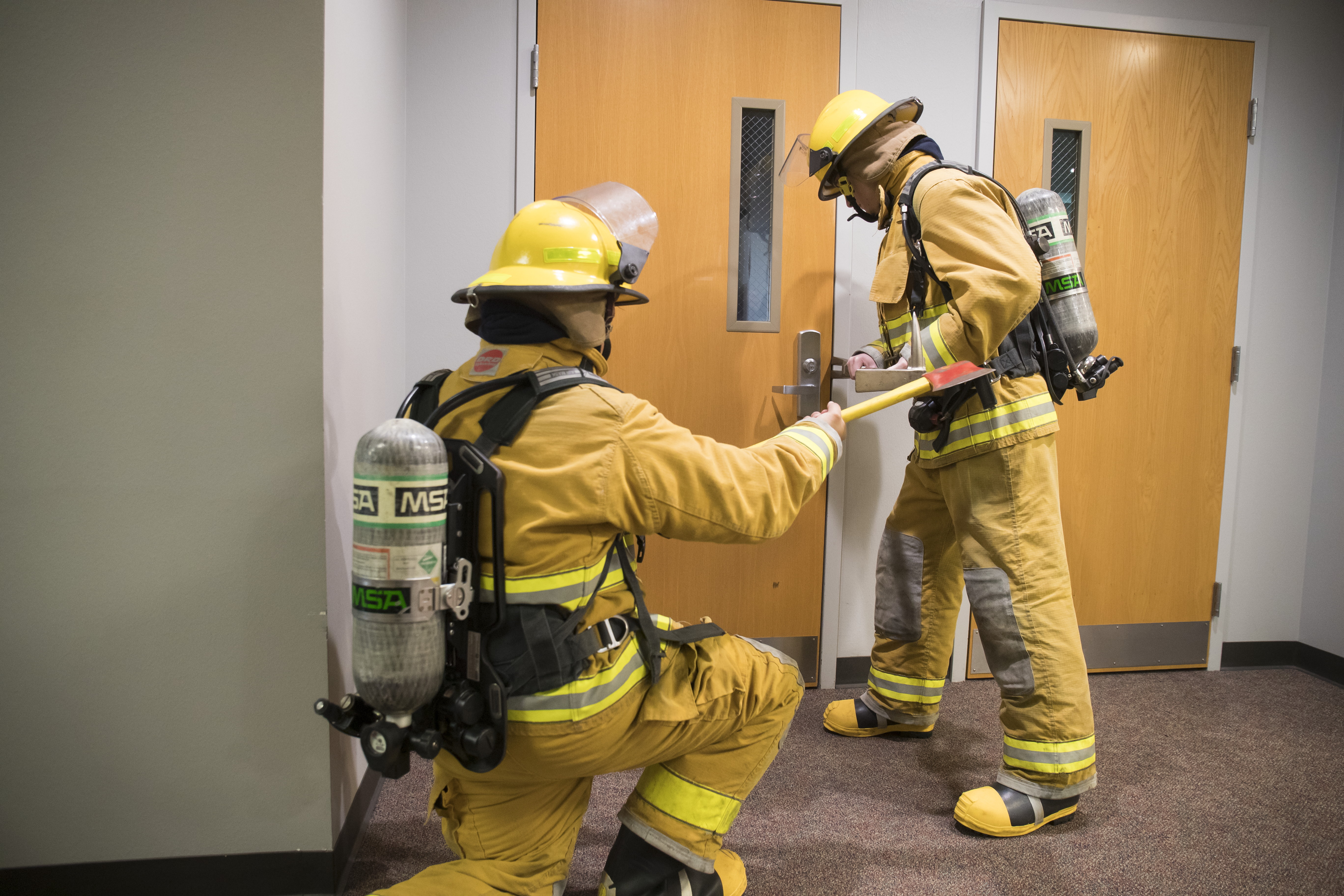 Firefighters using tool on door